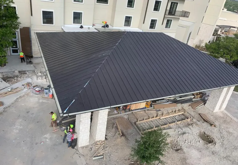 Metal roofing installation team working on a commercial building in Long Lake